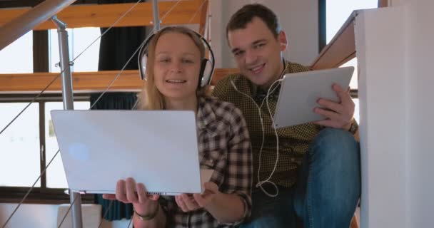 Νεαρό ζευγάρι σε heaphones στο σπίτι απολαμβάνοντας μουσική — Αρχείο Βίντεο