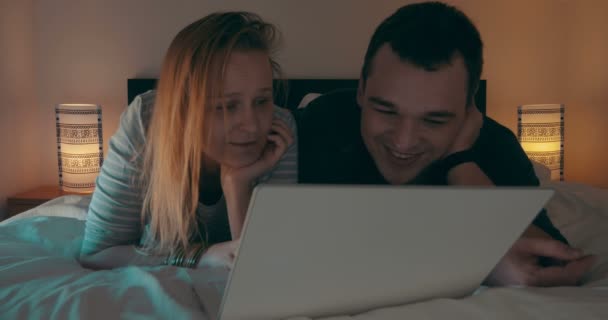 Par i sängen tittar på film på laptop — Stockvideo