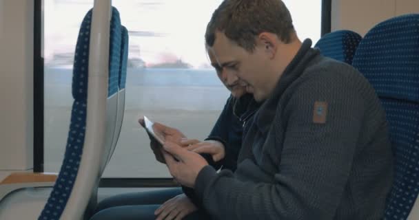 Young people entertaining with pad in the train — Stok video