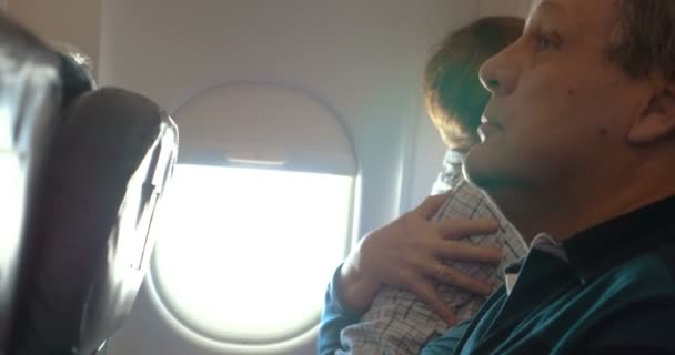 Niño y su abuela abrazándose en el avión — Vídeos de Stock