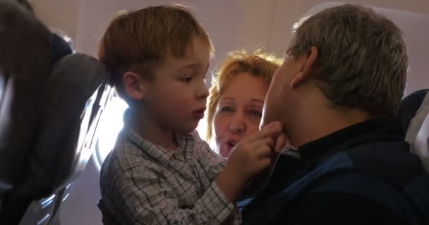 Enfant explorant grand-père visage dans l'avion — Video