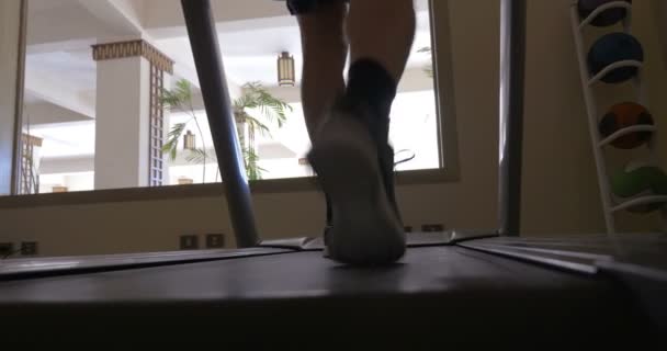 Ejercicio en la máquina de cinta de correr en el gimnasio del hotel — Vídeos de Stock