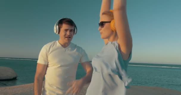 Homme et femme tirent du plaisir de la musique sur la plage — Video