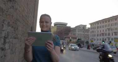 Young woman with pad having video chat outdoor
