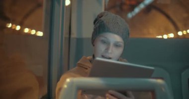 Woman traveling by bus with touch pad