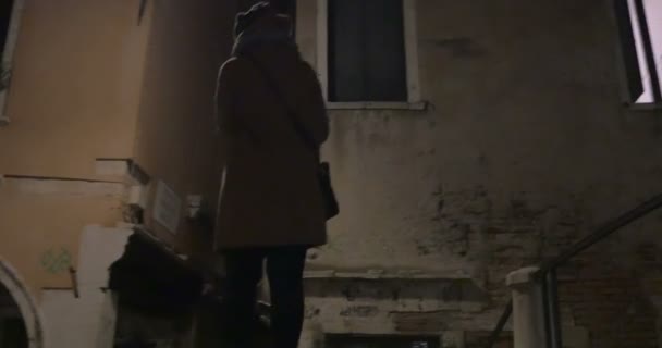 Woman with pad walking in narrow passages at night — Αρχείο Βίντεο