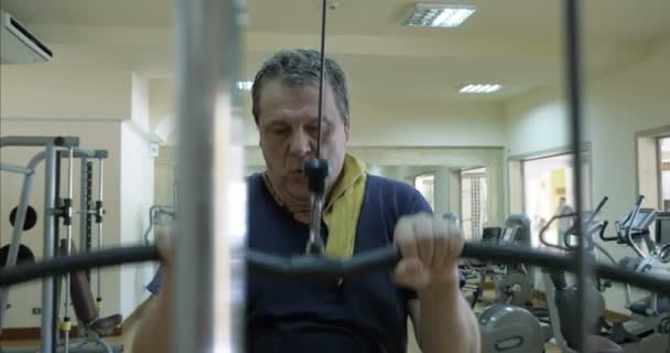 Зрелый человек работает на пулдаун-машине — стоковое видео