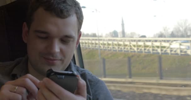 Człowiek rozmawiając na telefon komórkowy podczas jazdy pociągiem — Wideo stockowe