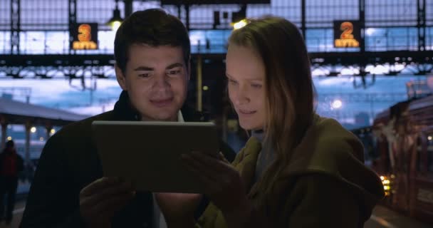 Young people using pad at station in the evening — 비디오