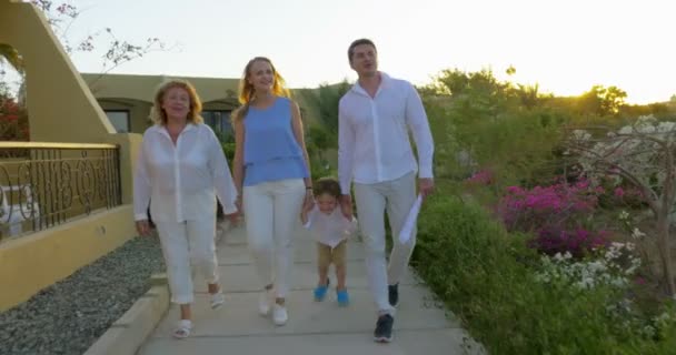 Familia caminando por la zona del resort por la noche — Vídeos de Stock