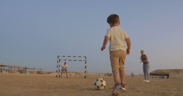 Chlapec je připraven udělat gól v tomhle plážovém fotbalu — Stock video