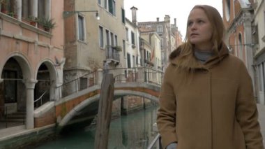 Woman having coffee while walking in Venice