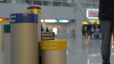 Geri dönüşüm kutusuna plastik su şişesi atan adam