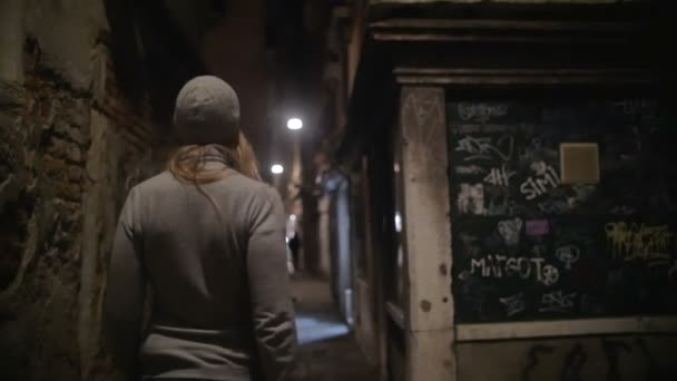 Woman wandering in dark alleyway at night — Stok video