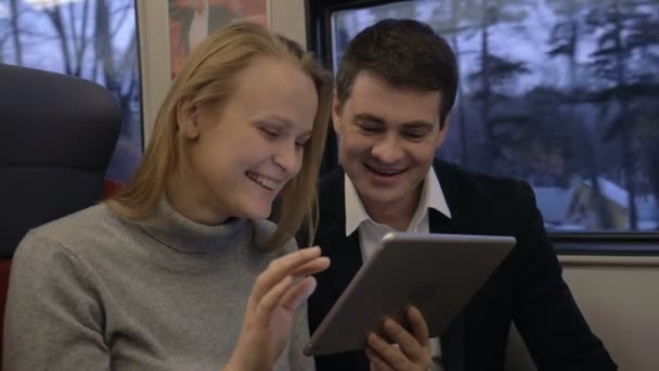 Amigos riendo mientras usan almohadilla en tren — Vídeos de Stock