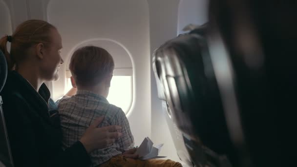 Menino e mãe olhando para fora através da janela do avião — Vídeo de Stock