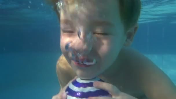 Buceo infantil con pelota en la piscina — Vídeo de stock