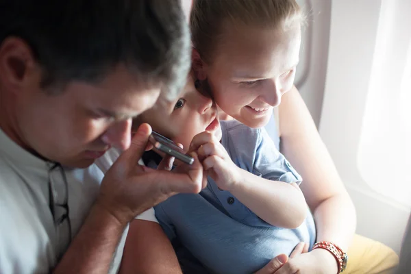 Parents and child listening something on the cell — Stockfoto