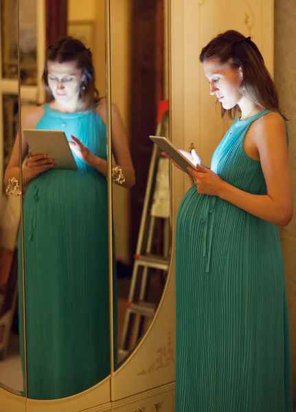 Έγκυος γυναίκα στο σπίτι χρησιμοποιώντας το tablet — Φωτογραφία Αρχείου