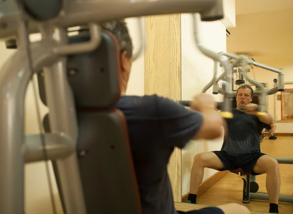 Mature man exercising on shoulder press machine — Stok fotoğraf
