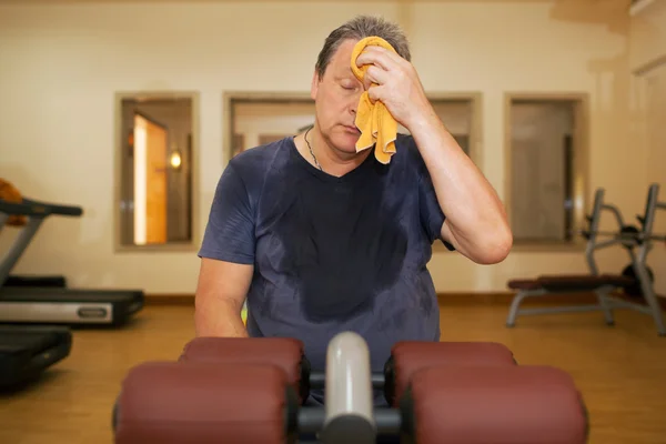 Tired man wiping sweat after workout — ストック写真