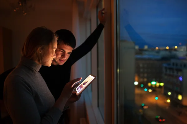 Couple with pad at home in the evening — Stock Photo, Image