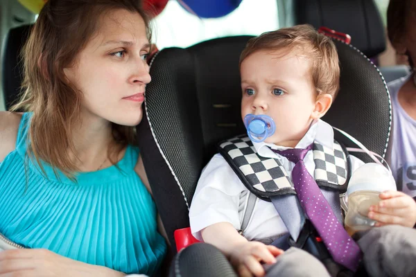 Mom looking at her son in child safety seat — Stock Photo, Image