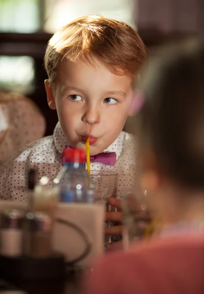 Little boy drinking with tubule — Stockfoto