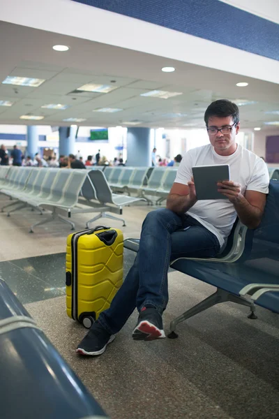 Junger Mann mit Touchpad in der Flughafenlounge — Stockfoto