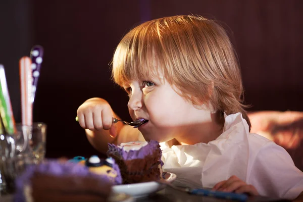 Niño comiendo pastel de chocolate — Foto de Stock