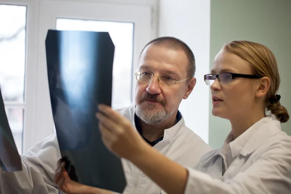 Kıdemli ve genç Doktor Röntgen görüntüleri inceleniyor — Stok fotoğraf