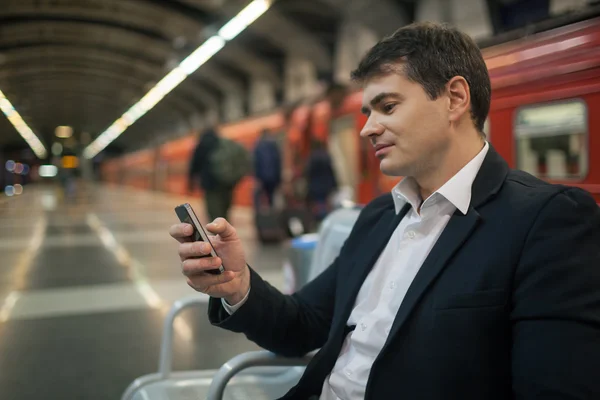 Zakenman met smartphone in Metro — Stockfoto