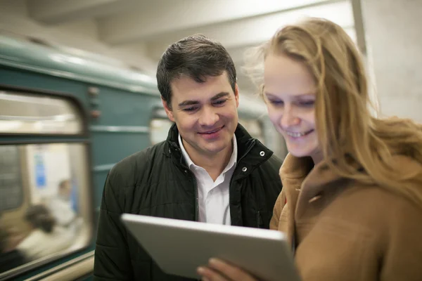 Jovens felizes com touch pad no metrô — Fotografia de Stock