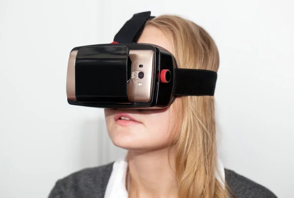 Женщина в VR-гарнитуре на белом фоне — стоковое фото