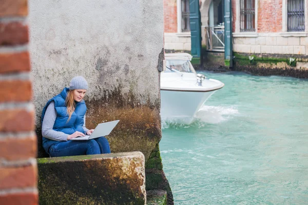 Jovem mulher usando laptop pelo canal em Veneza — Fotografia de Stock