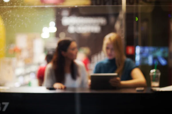 Two female friends using tablet PC in a cafe — Stock Photo, Image