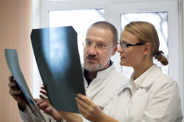 Профессор и молодой врач сравнивают рентген — стоковое фото