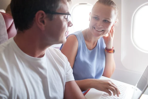 Happy young and woman with laptop in plane — 스톡 사진