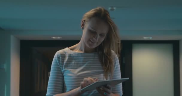 Frau läuft mit Tablet in der Hand durch den Gang — Stockvideo