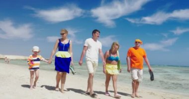 Sahilde keyifli bir yürüyüş alan aile