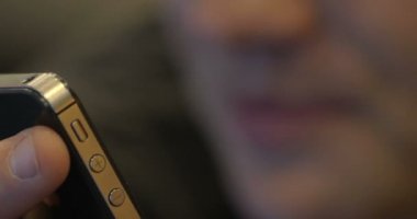 Genç gülümseyen adam cep telefonuyla video görüşmesi yapıyor.