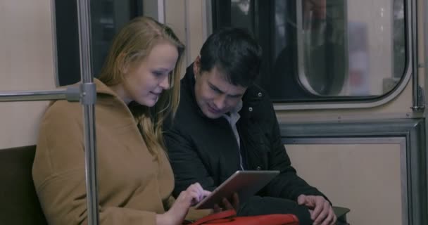Пара с планшетным ПК в общественном транспорте — стоковое видео