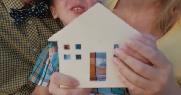 Onroerend goed concept met gelukkige familie en kleine houten huis — Stockvideo