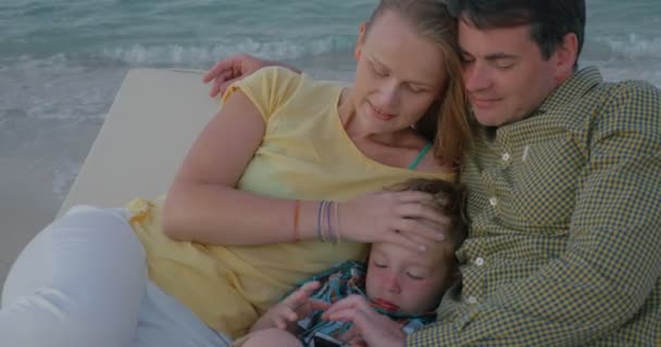 Young parents and child spending leisure time by the sea — 图库视频影像