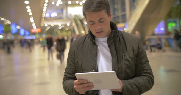 Чоловік використовує цифровий планшет в залі аеропорту — стокове відео