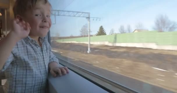 Junge winkt aus dem Zugfenster — Stockvideo