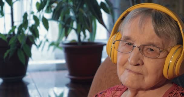 Пожилая женщина слушает музыку в наушниках — стоковое видео