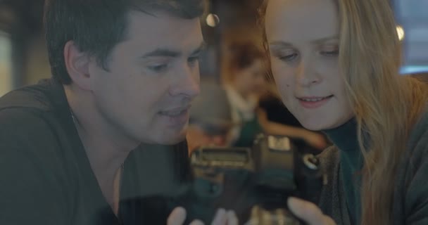 Young couple with camera choosing the best shots — Stock videók