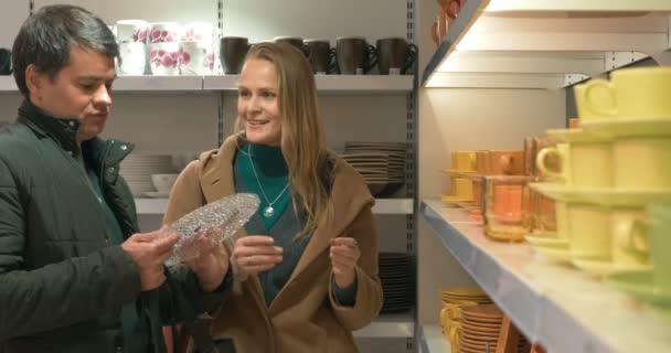 Young couple looking at dinnerware in the shop — Stockvideo