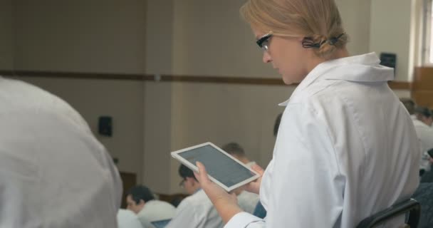 Medical student taking notes on pad during lecture — Stock Video